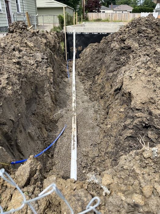 Open trench with sewer and water service run out to the street on a new home build